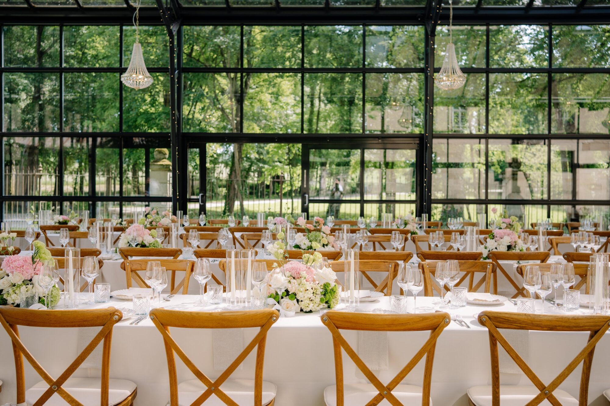 Lange Festtafel mit rosa und weißer Tischdekoration im Glaspavillon